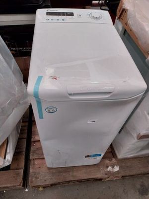 un réfrigérateur blanc posé sur une palette, à côté d'autres appareils électroménagers