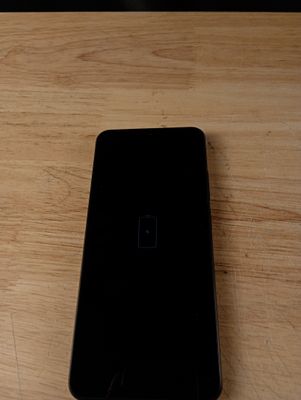 un téléphone portable noir posé sur une table en bois