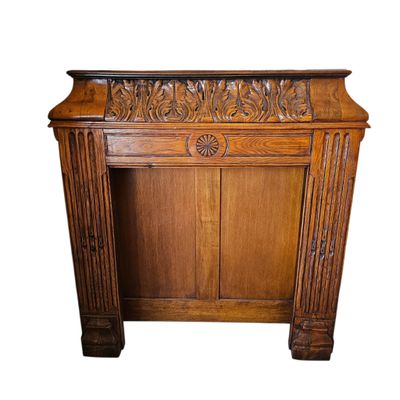 an old wooden cabinet with carvings on the top of it
