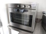 a stainless steel oven that is sitting on a shelf