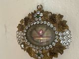 une horloge accrochée au mur et ornée d'une multitude de bijoux