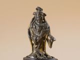 bronze figurine of a woman holding a bird on a pedestal