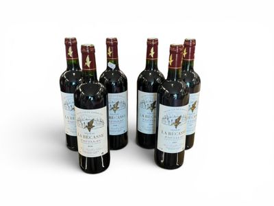 quatre bouteilles de vin sont alignées sur une surface blanche