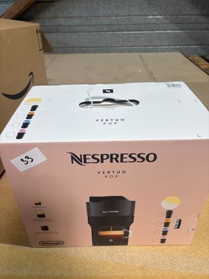 packaging of a coffee machine sitting on a table next to a cardboard box