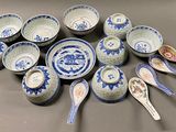 a lot of blue and white bowls and spoons on the table
