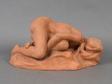 a statue of a woman laying on a rock with her head on the ground