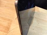 a black cell phone sitting on top of a wooden table