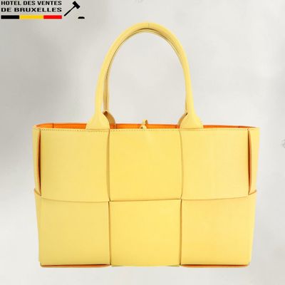 a close up of a yellow handbag on a white background