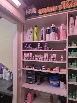 une salle de bains dont les étagères regorgent de produits capillaires