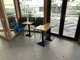 deux tables et des chaises dans une pièce dotée d'une grande fenêtre