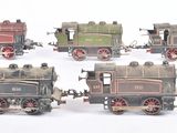 quatre petits trains jouets posés côte à côte sur une surface blanche