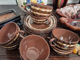 a lot of dishes and cups sitting on a table