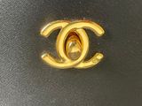 chanel logo on a black leather bag with a gold chain