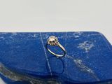un gros plan d'une bague en diamant posée sur une pierre bleue