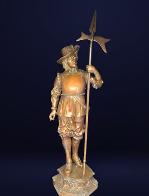 statue en bronze représentant un homme muni d'une faux et tenant un drapeau