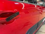 a red car that has a sticker on the side of it