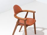 une chaise en bois avec une assise en cuir dans une pièce blanche
