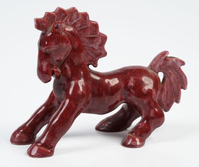 figurine représentant un cheval rouge sur fond blanc