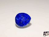 a close up of a blue stone sitting on top of a white surface