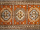 un tapis orange et bleu orné de quatre médaillons