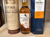 Deux bouteilles de whisky sont posées sur une étagère dans un magasin.