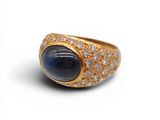 une image représentant une bague en or sertie d'une pierre bleue entourée de diamants blancs