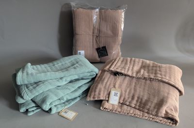 two blankets and a bag of blankets are sitting on a table