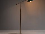 un lampadaire vert posé sur une surface blanche, devant un mur blanc