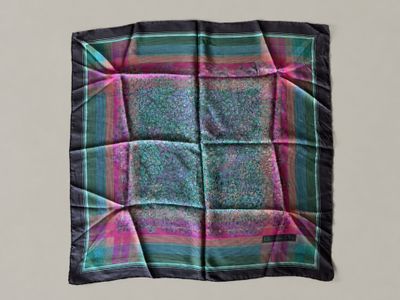 a close up of a square scarf on a white surface
