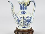 a blue and white vase sitting on a wooden stand