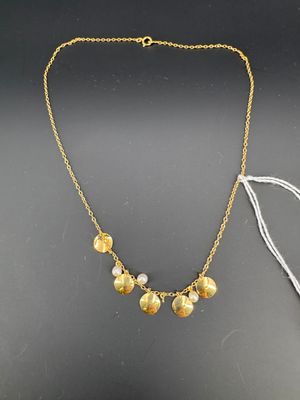 un collier doré et blanc composé de cinq petites perles montées sur une chaîne