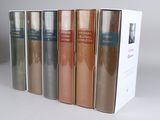 four books in a row on a white surface with a white background