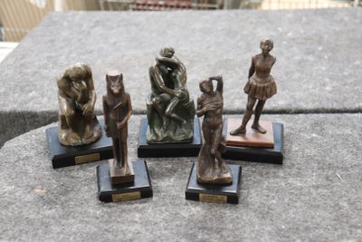 quatre figurines en bronze représentant une femme, un homme et un chat