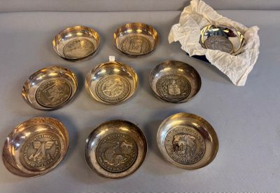 six bols en argent et un sac de pièces d'argent posés sur une table