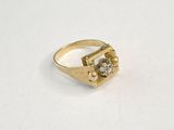 gros plan d'une bague en or sur une surface blanche