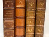 trois vieux livres sont empilés les uns sur les autres, alignés en rangée