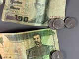three different bills and coins on a table next to each other