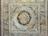 an antique rug with a floral design on a brown ground