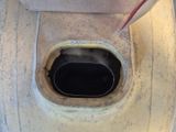 des toilettes sales avec un siège noir et une poignée rouge