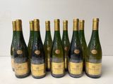six bottles of wine are lined up in a row on a table