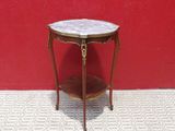 une petite table avec un plateau en marbre devant un mur rouge