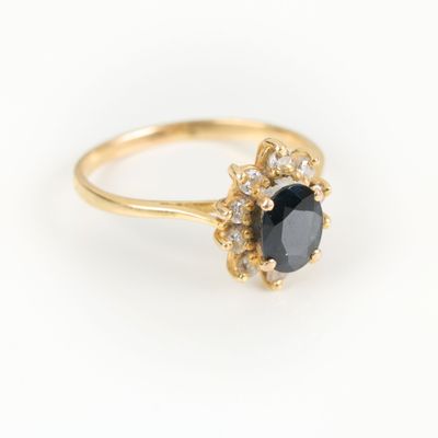 a gold ring with a black stone surrounded by white diamonds