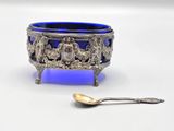 a blue glass bowl and a spoon on a white surface