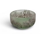 a small glass bowl with trees in the background