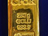 a close up of a gold bar on a blue surface