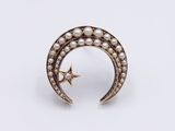 a gold crescent and star broochle with pearls