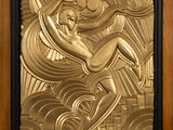 an art deco plaque depicting a woman on a surfboard in gold
