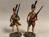 deux figurines de soldats armés et en uniforme, posées sur une surface blanche