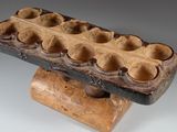 a wooden object with holes in it on a stand