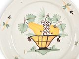a plate with a basket of fruit painted on it